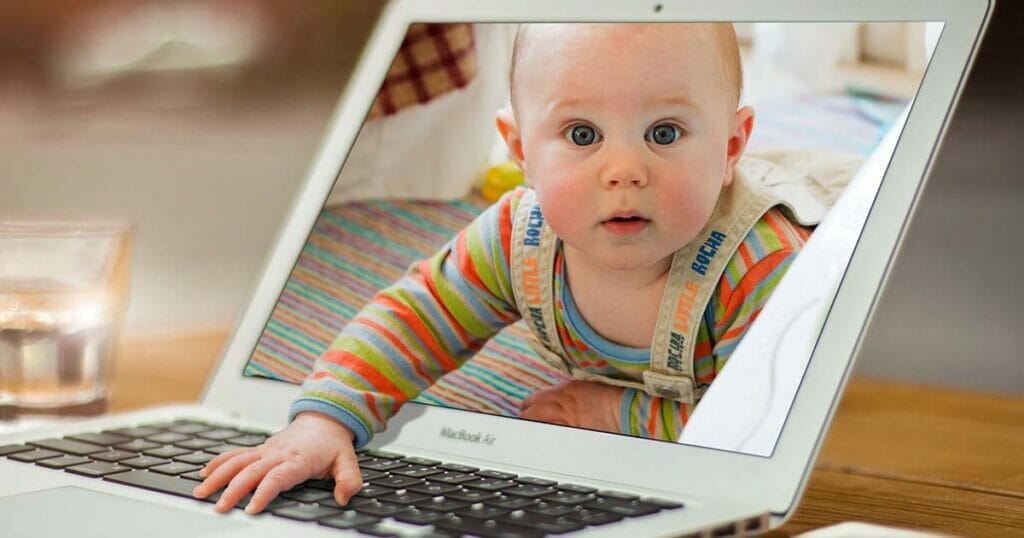 Das Gesicht eines Babys ist auf dem Bildschirm eines Laptops zu sehen und zeigt die Kunst des Grafikdesigns.