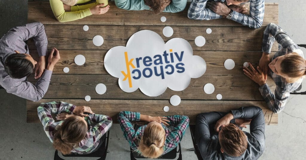 Eine Gruppe von Menschen, die an einem Tisch sitzen und sich über die Optimierung und Automatisierung von Prozessen und Workflows in KMU unterhält.