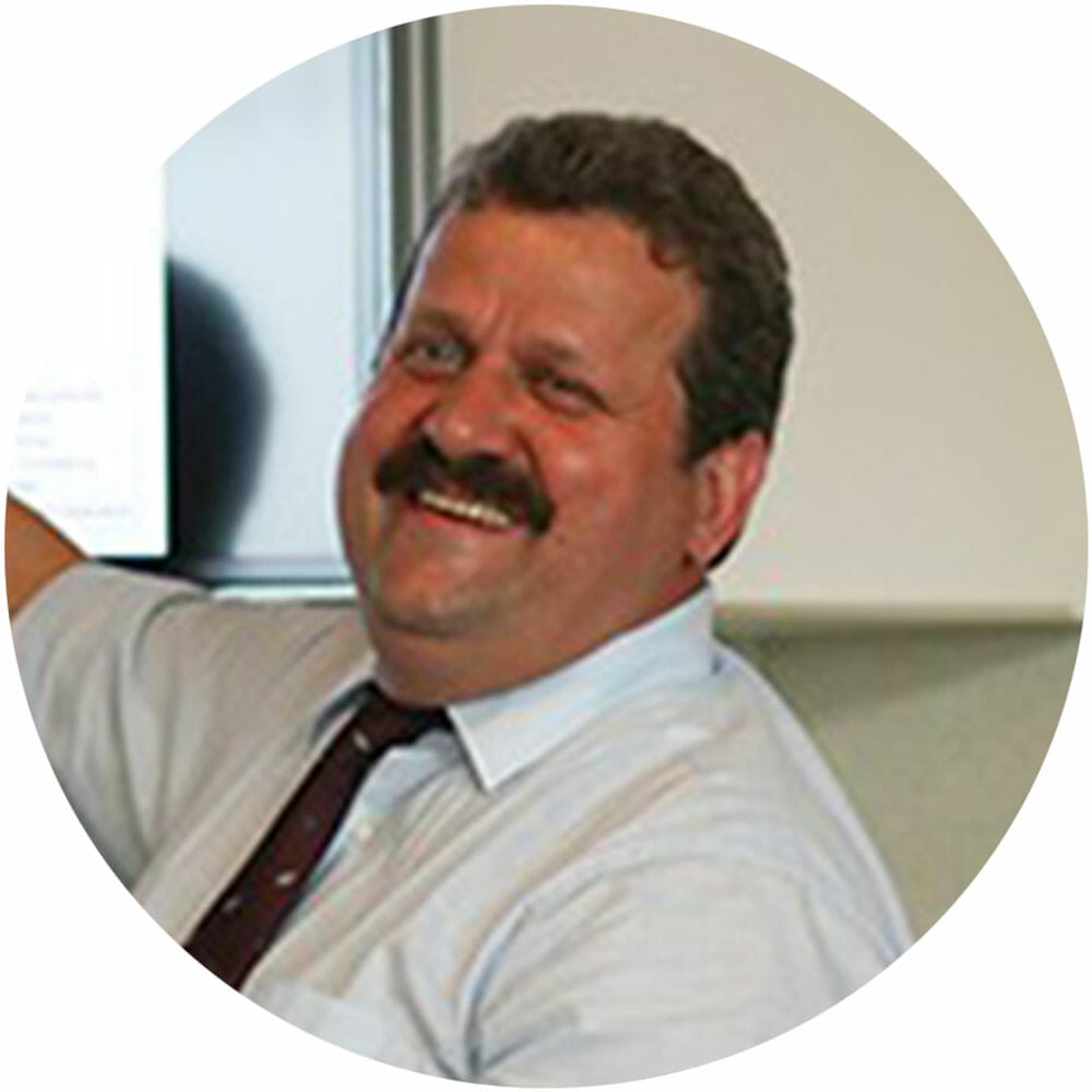 Ein Mann lächelt vor einem Computerbildschirm und ist Kunden von kreativschock und hat eine Website für sein Küchenunternehmen erhalten.