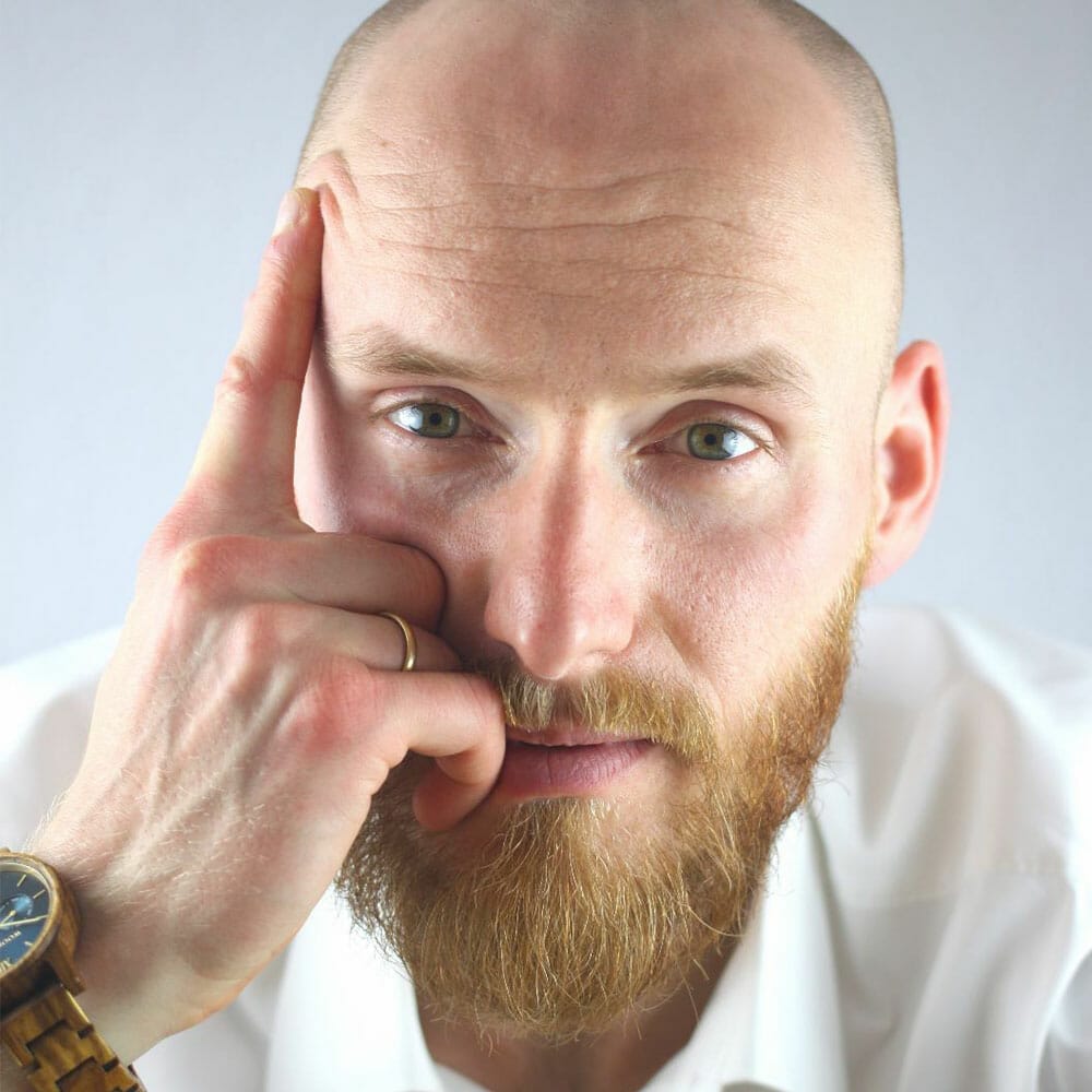 Ein Mann mit Bart und weißem Hemd, Kunde von kreativschock, der eine Website für sein Startup erhalten hat.